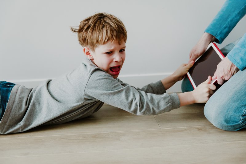 child holding an ipad, angry